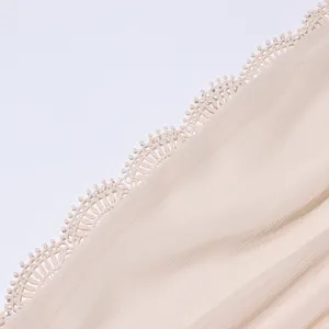 Detail de tissu de bordure en dentelle vintage et texture plisee de robe de femme elegante