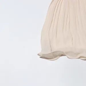 Vue détaillée du tissu de jupe plissée vintage élégant montrant une texture estivale fine.