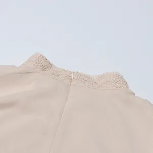 Gros plan détaillé sur le col arrière de la robe beige élégante avec fine dentelle.