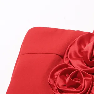Nahaufnahme Detail des roten Damen Slip-Kleides mit wunderschönem 3D Rosen Stoffblumen Design.