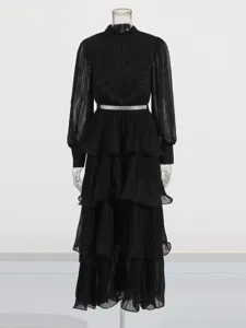 Robe longue élégante noire à manches longues avec volants étagés, broderie et ceinture.