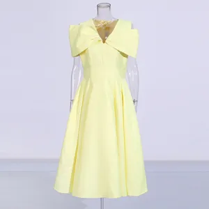 Detailed view of the elegant yellow bow v-neck dress showcasing the exquisite waist-cinching fit.