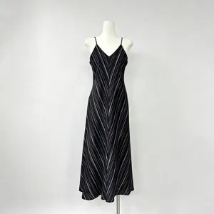 Detailopname van de elegante jurk met fijne schouderbandjes en stijlvol gestreept patroon.