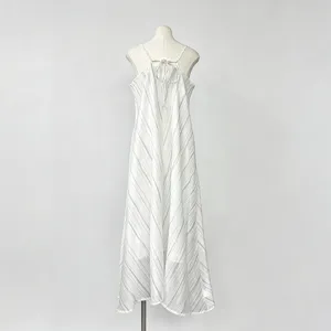 Detailweergave van een elegante witte gestreepte maxi-jurk met spaghettibandjes.