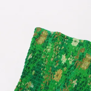 Detalle de vestido de gasa floral verde smock, tela elástica con volantes, moda.