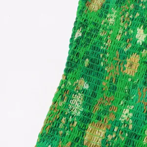 Detalle de primer plano de tela nido de abeja con estampado floral verde para mujer