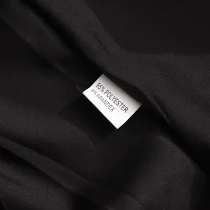 Gros plan detaille sur le tissu et l'etiquette de composition de la robe noire elegante.