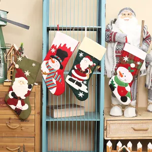 Bestickte Weihnachtssocken, große Geschenktüten und hängende Dekorationen für den Kamin.