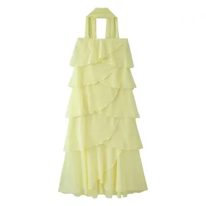 Longue robe maxi à volants en mousseline jaune avec élégants rubans de cou stylés.