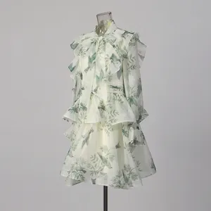 Detailed view of green bird print ruffled long sleeve dress, sheer fabric forest style design.