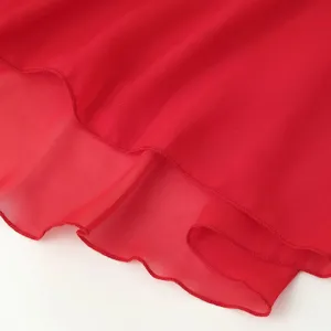 Vue détaillée de l'ourlet de la robe en mousseline rouge, texture légère et fluide.