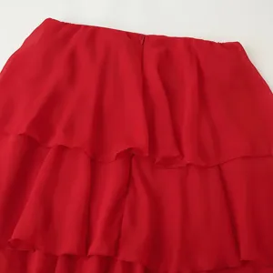 Vue détaillée de la robe longue bustier en mousseline rouge avec des volants superposés.