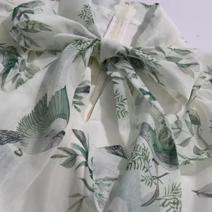 Close-up detail of the light cyan bird patterned dress collar with elegant big bow tie.