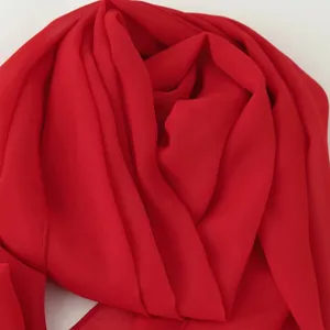 Détail de tissu mousseline rouge, texture de drapé élégante, toucher doux, gros plan robe été.