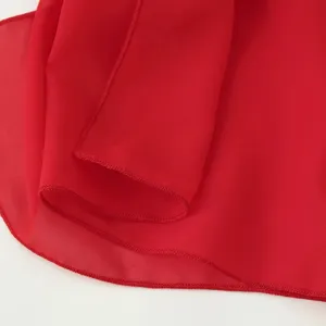 Détail d'ourlet de robe en mousseline rouge, gros plan de tissu élégant, texture lisse d'été.
