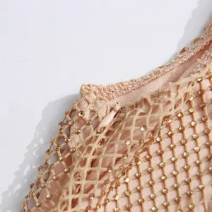 Gros-plan d'une robe nuisette en résille strassée sexy, avec cristaux et détail de fermeture.
