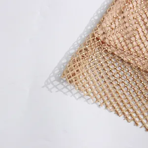 Vue détaillée d'un tissu résille scintillant orné de strass couleur champagne chic, gros plan.