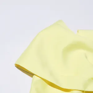 Light yellow solid color dress detail shot, highlighting smooth fabric texture and exquisite tailoring.