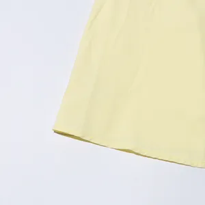 Close up detail view of solid color dress hemline, featuring neat stitching and soft fabric.