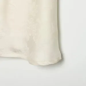 Primo piano dettagliato di tessuto jacquard in raso albicocca con cuciture dell'orlo pulite.