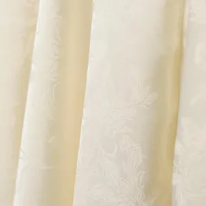 Primo piano dettagliato del tessuto jacquard albicocca liscio con delicata trama floreale.