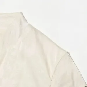 Dettaglio abito albicocca primo piano tessuto mostra consistenza morbida jacquard.