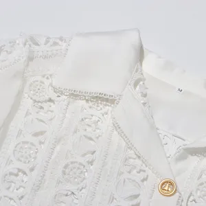 Close-up detail of white lace embroidered lapel blouse with delicate hollow-out patterns.