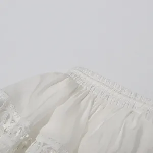 White lace trim garment detail, exquisite hollow embroidery design, elegant summer style.