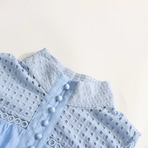 Vue rapprochée du col montant élégant brodé de broderie anglaise bleu clair et des boutons.