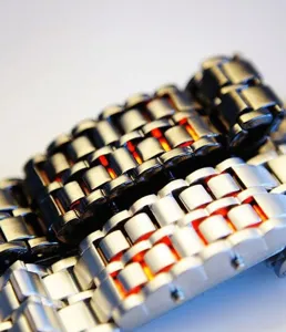 Detailansicht der stilvollen Metall LED Lavauhr mit leuchtend roten Lichtern und Edelstahlarmband.