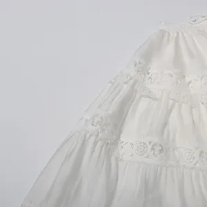 Detail shot of white tiered skirt with delicate lace trim, elegant retro aesthetic design.