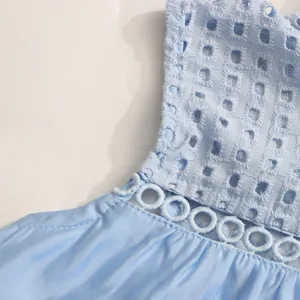 Détail de robe sans manches bleu clair avec broderie anglaise élégante et dentelle.