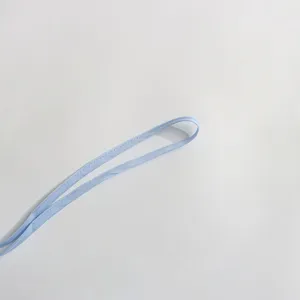Vue détaillée d'une bretelle de robe bleu clair, avec des coutures nettes et un tissu.