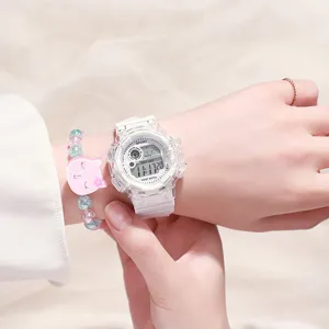 Gros plan de la montre numérique blanche transparente portée au poignet avec un bracelet.