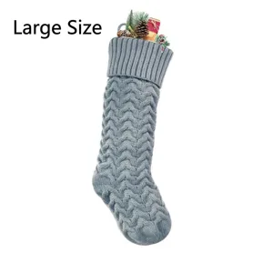 Grey knitted Christmas stocking with wave pattern, holiday hanging decor gift bag detail.