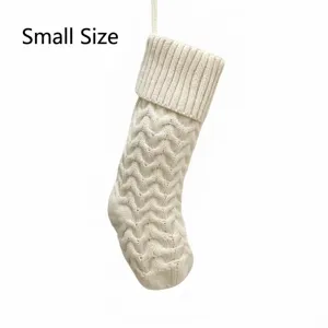 Small knitted Christmas stocking detail, white wave pattern hanging decoration for holiday.