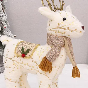 Primo piano di decorazione natalizia renna in peluche con stampa glitter, sciarpa e sella.