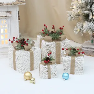 Vue detaillee de l'ensemble de boites cadeaux de Noel en rotin avec noeuds en jute et baies.