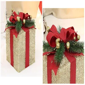 Vue détaillée de la boîte cadeau de Noël avec nœud en toile de jute rouge et boules dorées.
