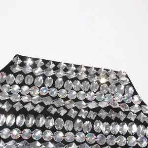 Detailed shot of sparkling rhinestone embellished black fabric, shiny crystal design.