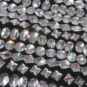 Close-up macro detail of sparkling clear multi-shape rhinestones sewn on black fabric.