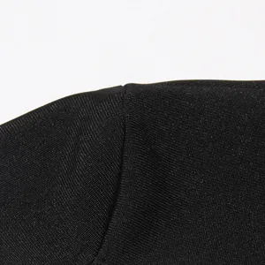 Close-up detail of premium black textured fabric showing fine knit stitch and neat stitching.