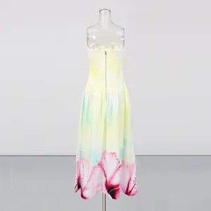 Close-up details of the gradient yellow strapless long dress featuring smocked back and floral hem.