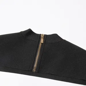 Detailed close-up view of the back zipper and high collar on a modern black top design.