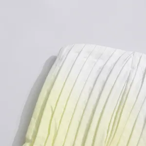 Gradient yellow pleated fabric detail of women's summer strapless long dress resort wear.