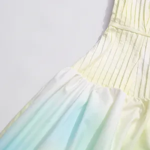 Close-up detail of pleated gradient maxi dress, highlighting fabric texture and color block design.