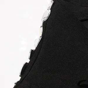 Close up view of black bandage dress edge embellished with sparkling rhinestones for women