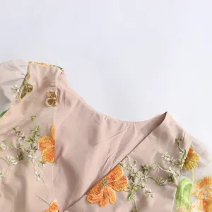 Close-up detail of women's floral embroidered mesh dress, showing exquisite neckline craftsmanship.