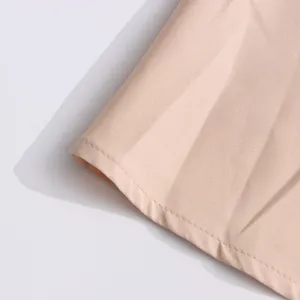 Detailed view of light pink women dress fabric showing fine stitching and smooth pleat texture.
