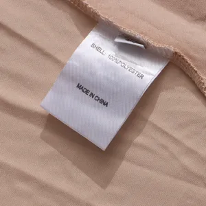 Detail shot of clothing care label showing 100 polyester material and pleated fabric.